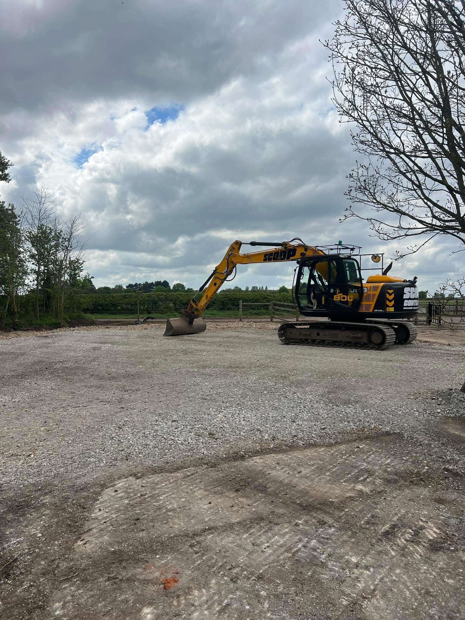 Excavator preparing gravel hardstanding