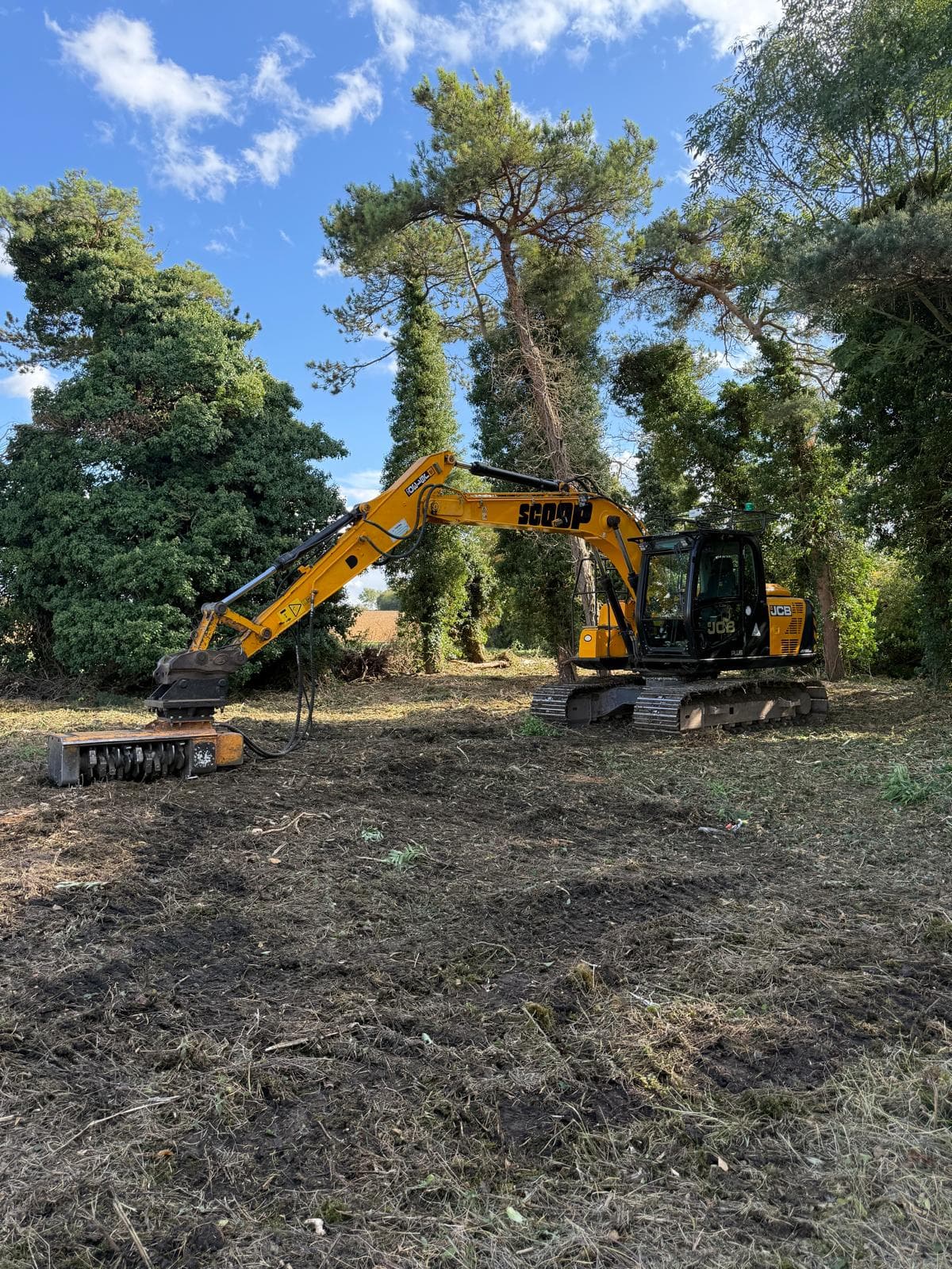 Excavator clearing trees on a construction site
