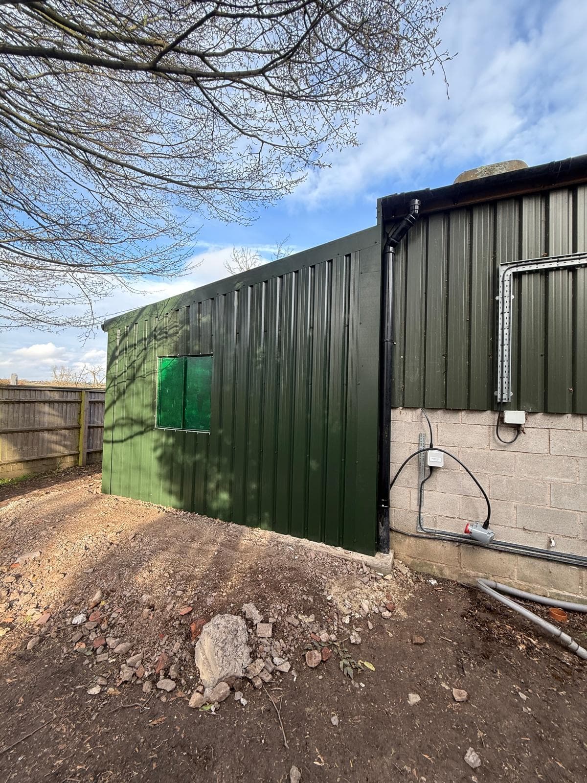 Side view of green steel clad agricultural building