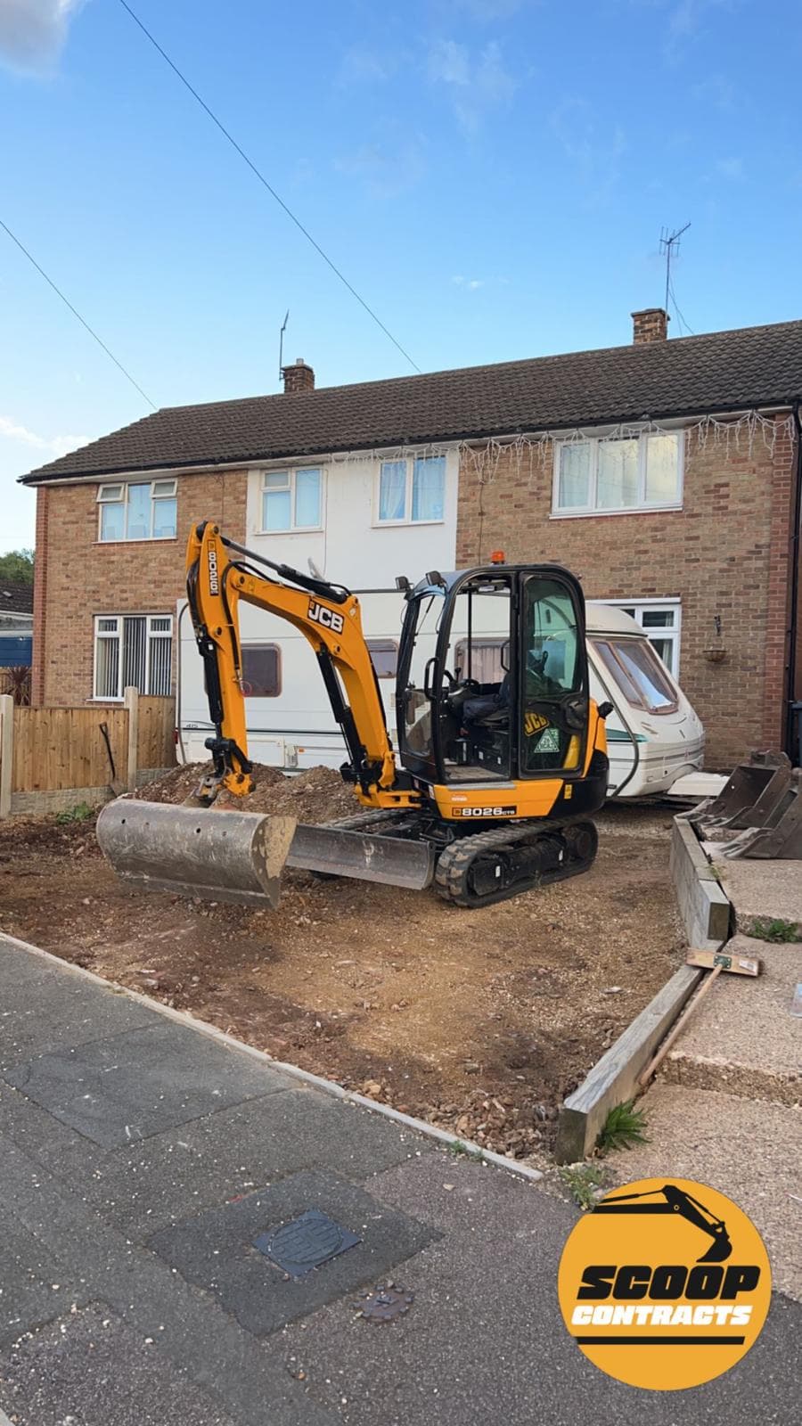 Mini excavator working on residential driveway