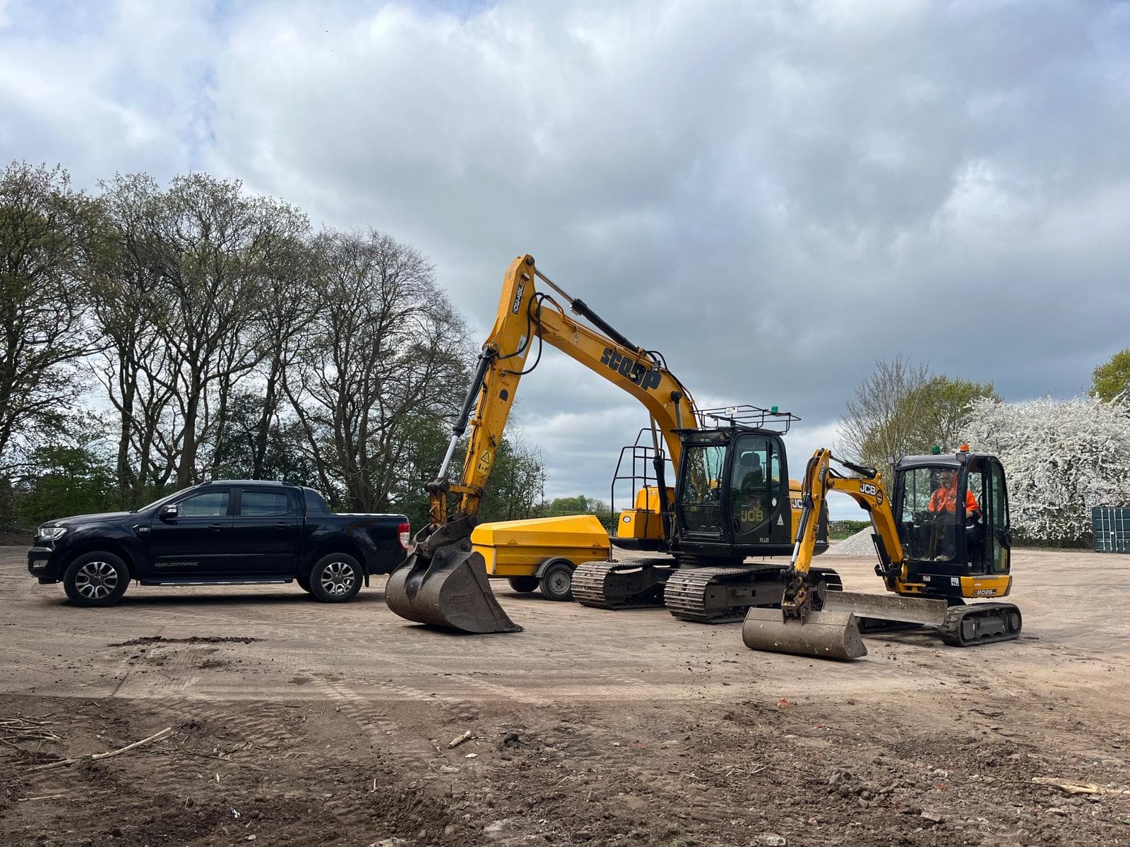 Scoop Contracts excavators and pickup truck on site