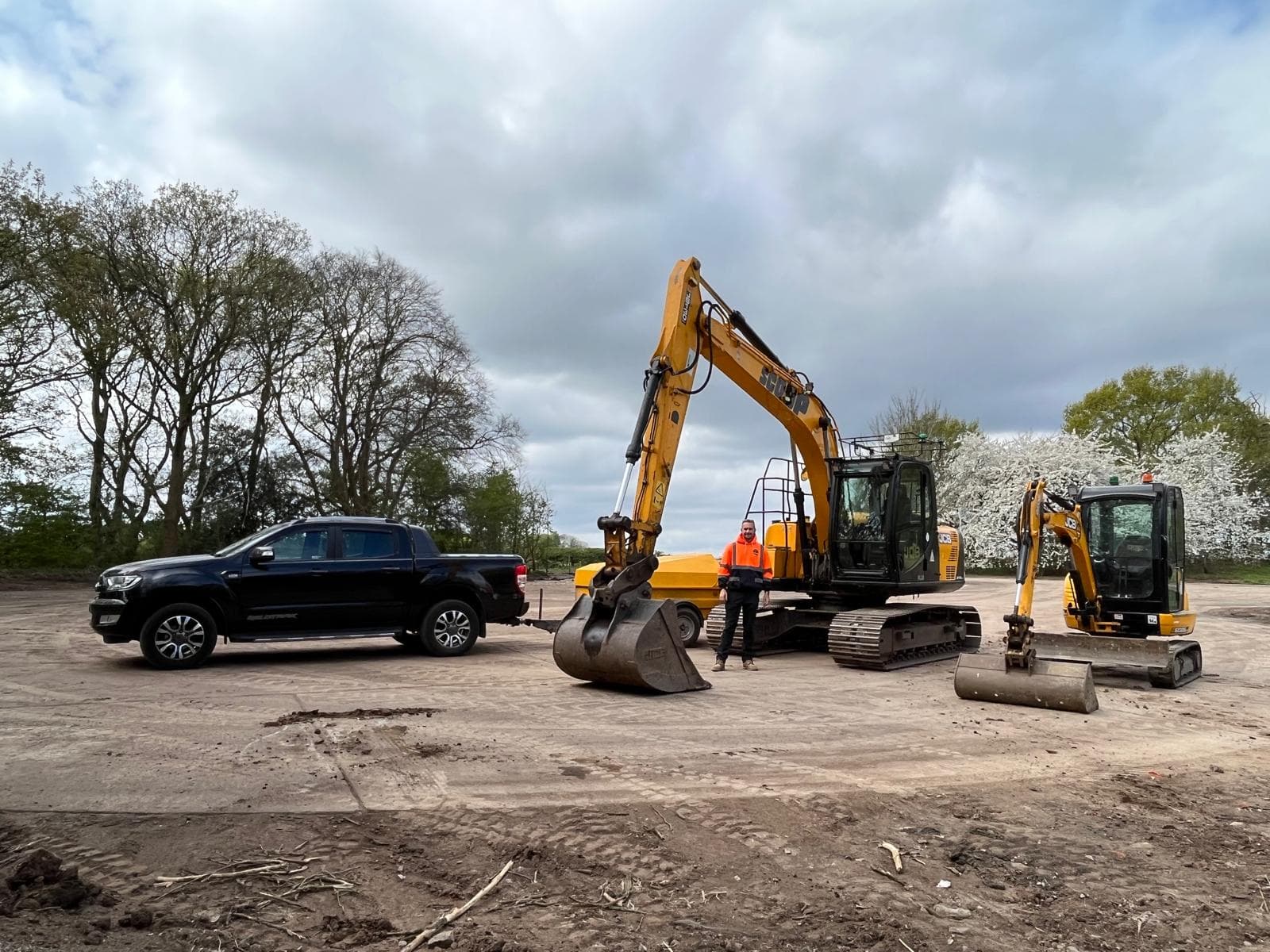 Team portrait with excavators and pickup